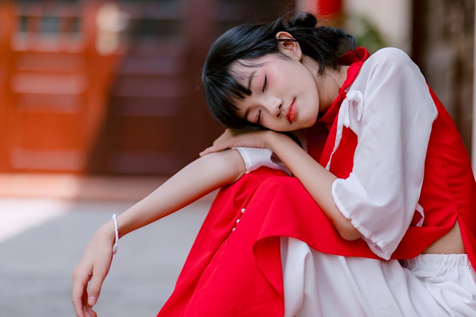 暖かい日に外で休んでいる、赤と白の服を着たリラックスした若い女性。