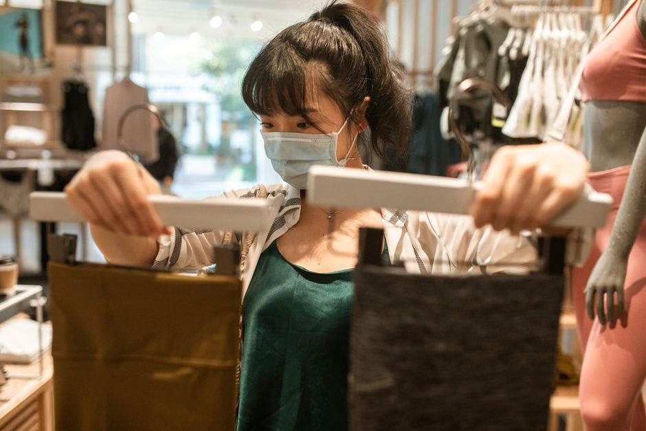 白いタブレットコンピューターを保持している緑のタンクトップの女性