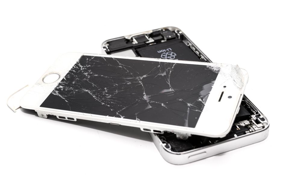 ひび割れた画面を持つ壊れたスマートフォンのクローズアップ。