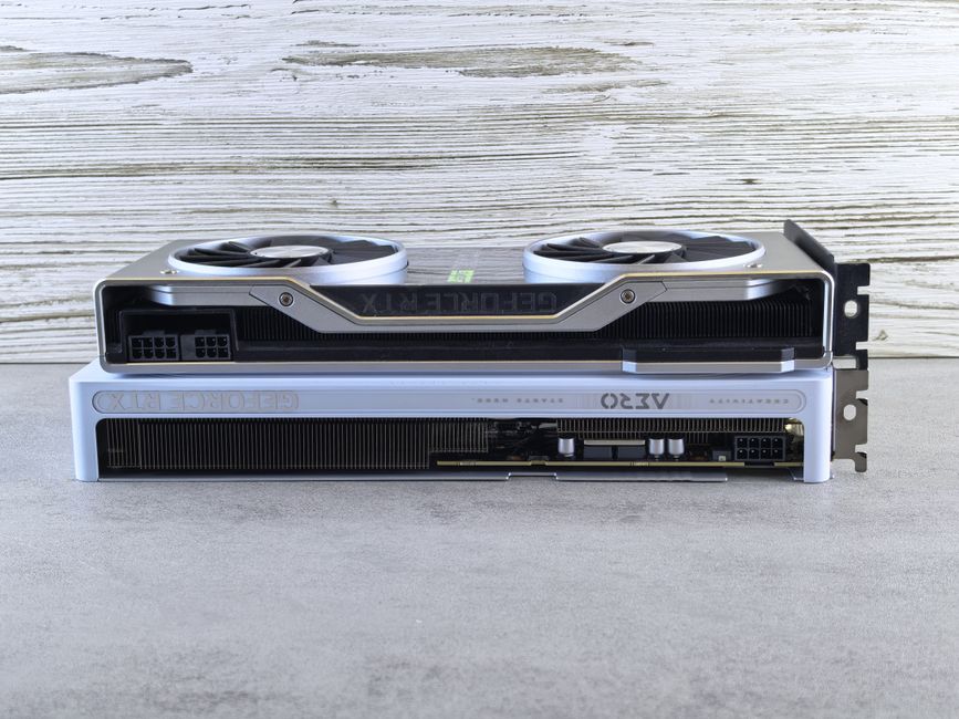 木製の表面に積み重ねられた 2 枚のモダンなグラフィック カード。洗練されたデザインと高度なテクノロジーが披露されています。