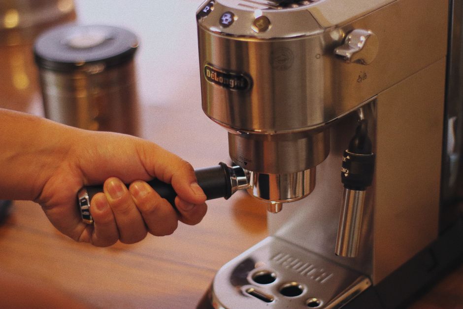 ステンレス製のエスプレッソマシンを使ってコーヒーを作る人。